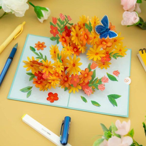 Papercrush pop-up kaart kleurrijke madeliefjes met vlinder kaart op tafel